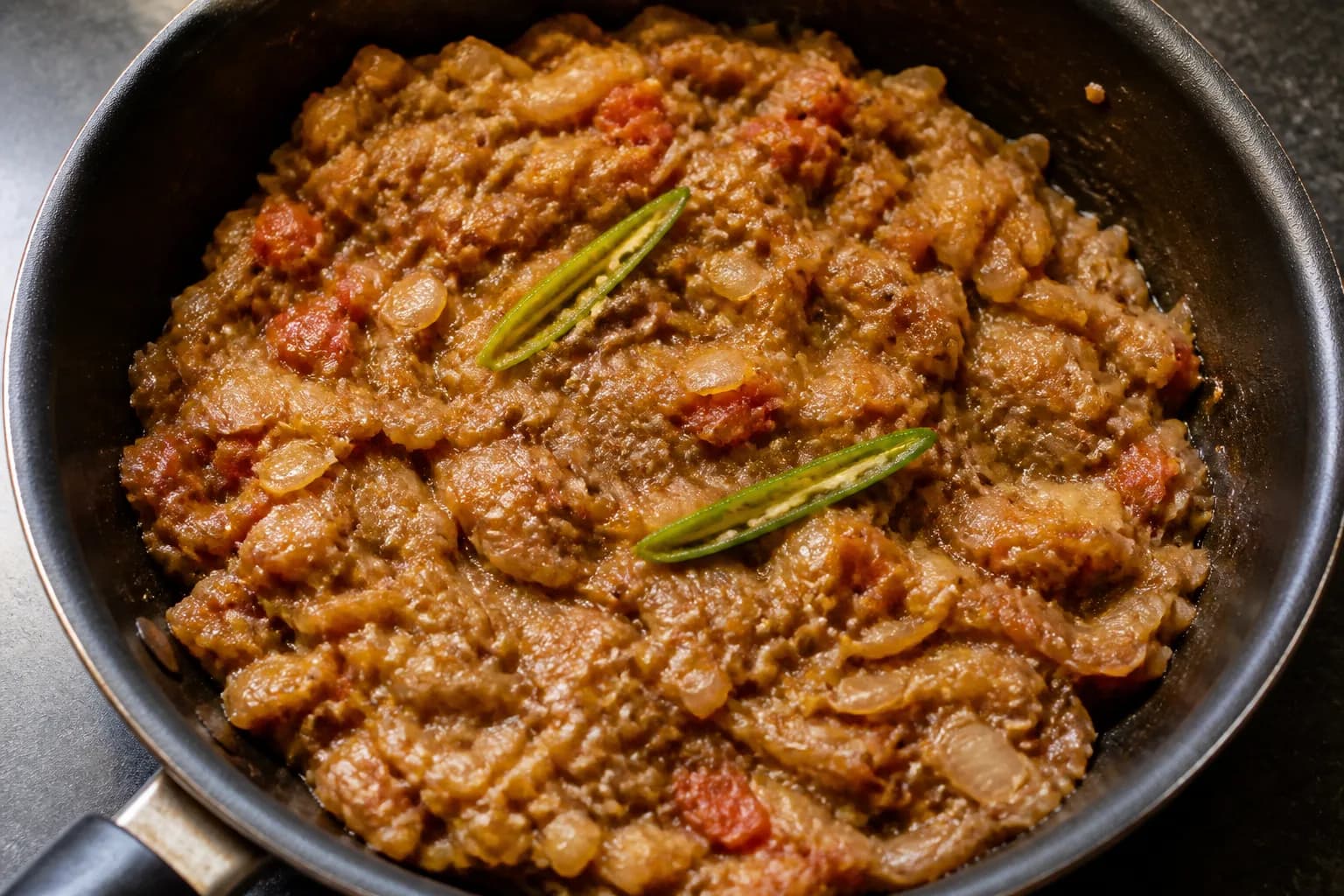 Soft fibrous roasted aubergine folded through onion and tomato masala with green chillies