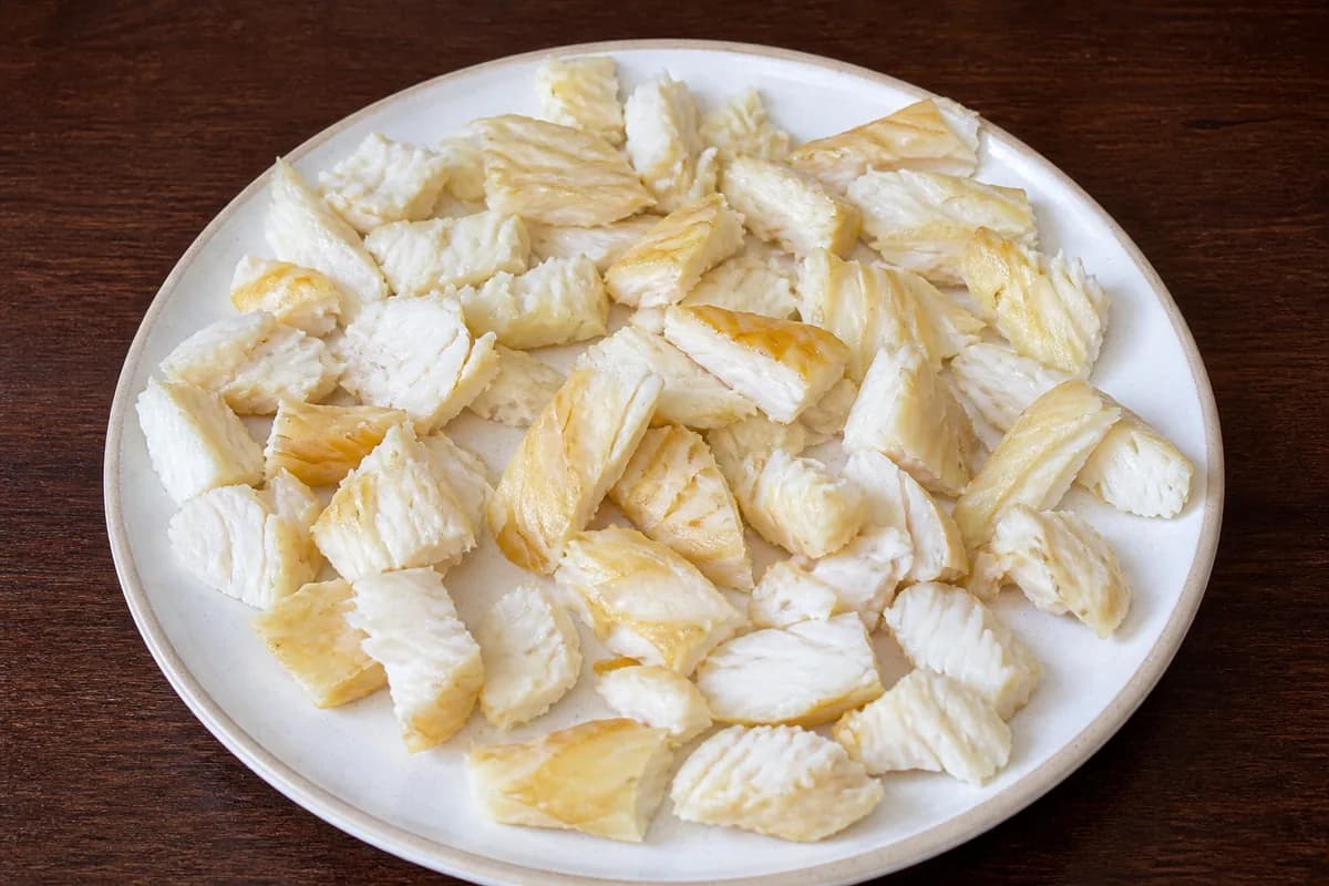 Pieces of undyed smoked haddock with the skin removed on a wooden board